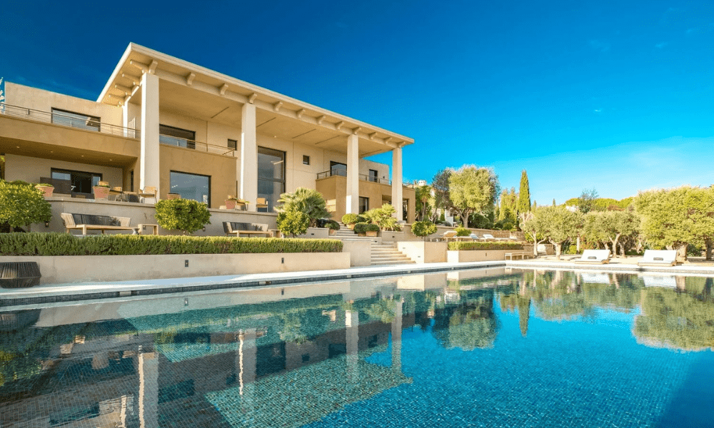 Infinity pool bordered by garden and panoramic views